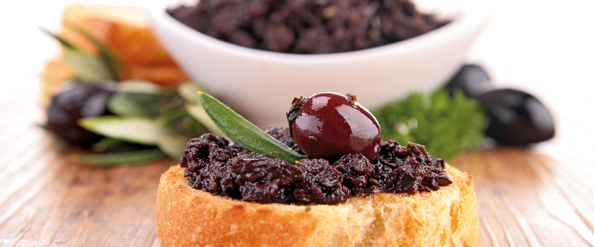 Bruschette con paté di olive su piatto