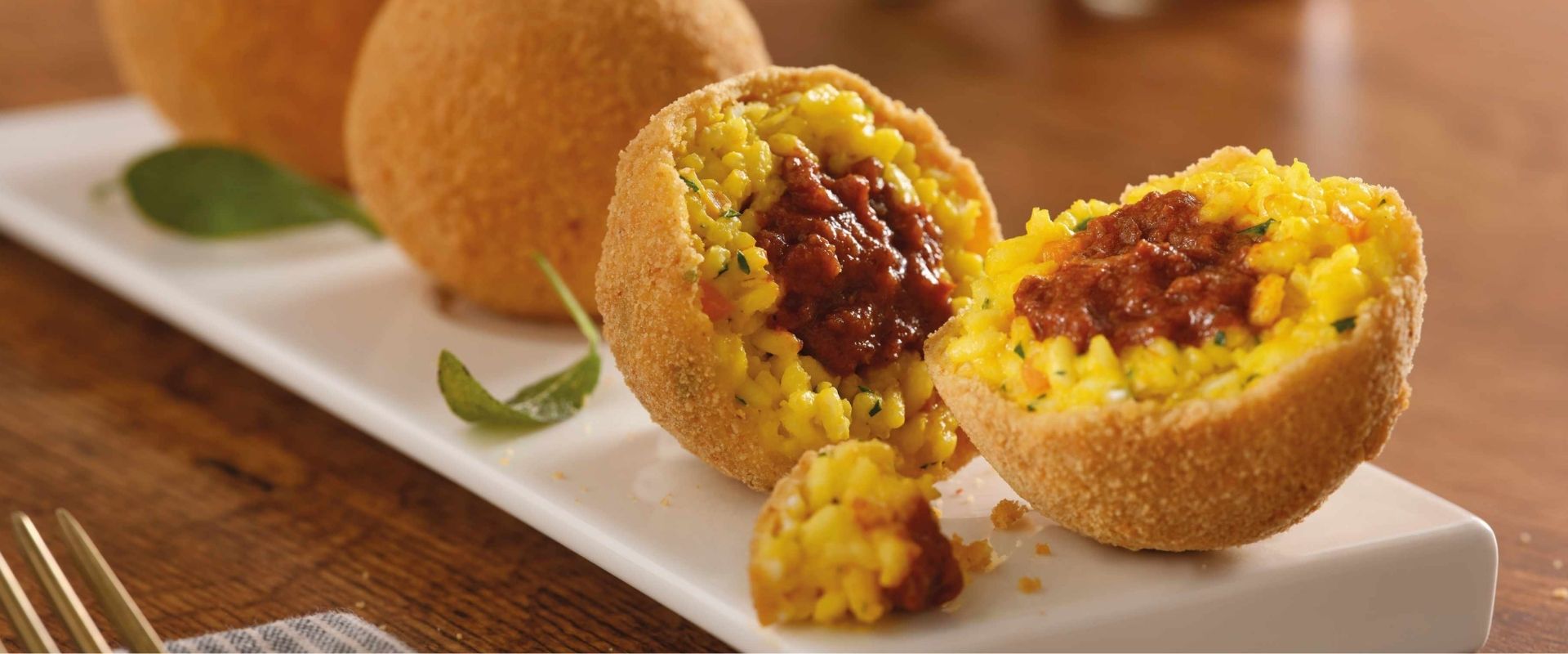 Arancini di riso allo zafferano con cuore di ragù, sapori della cucina italiana 