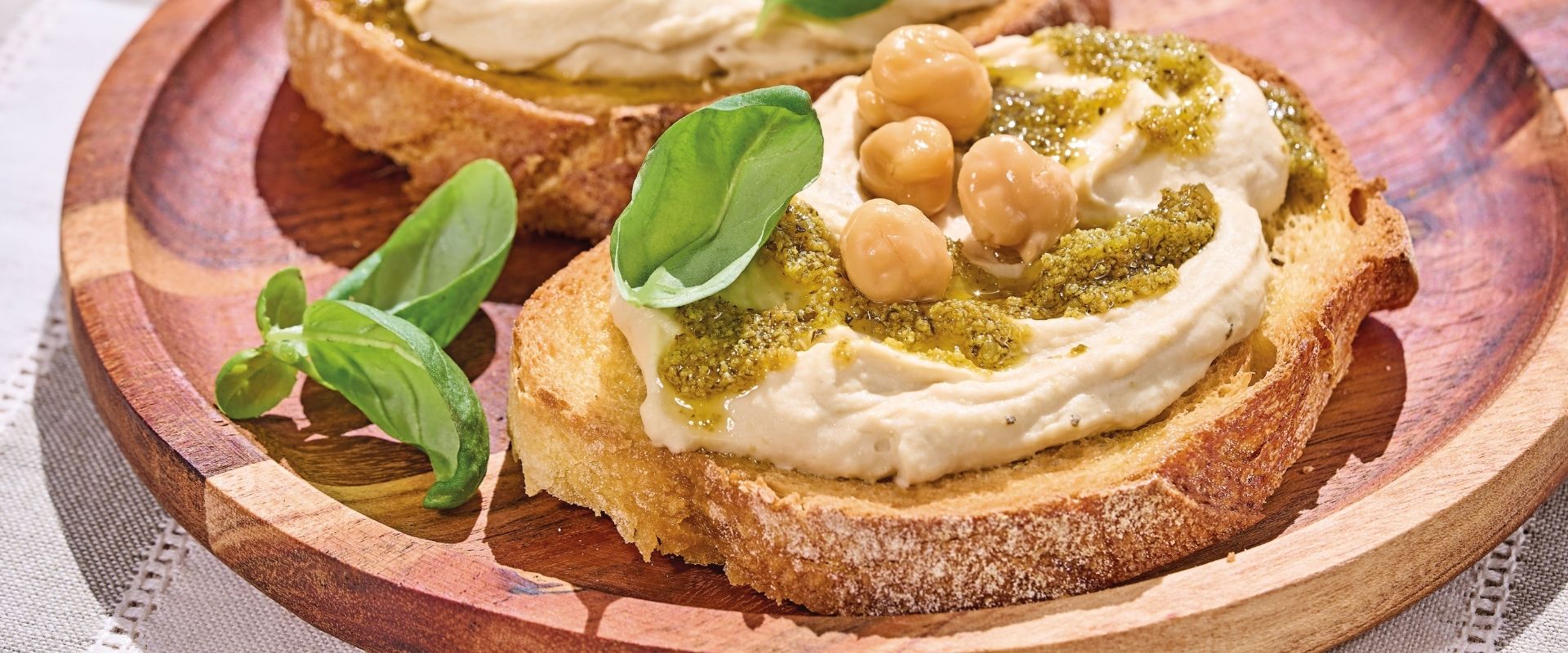 bruschetta di pane tostato con pesto, ceci e hummus ricetta veloce per usare il pesto in modo diverso