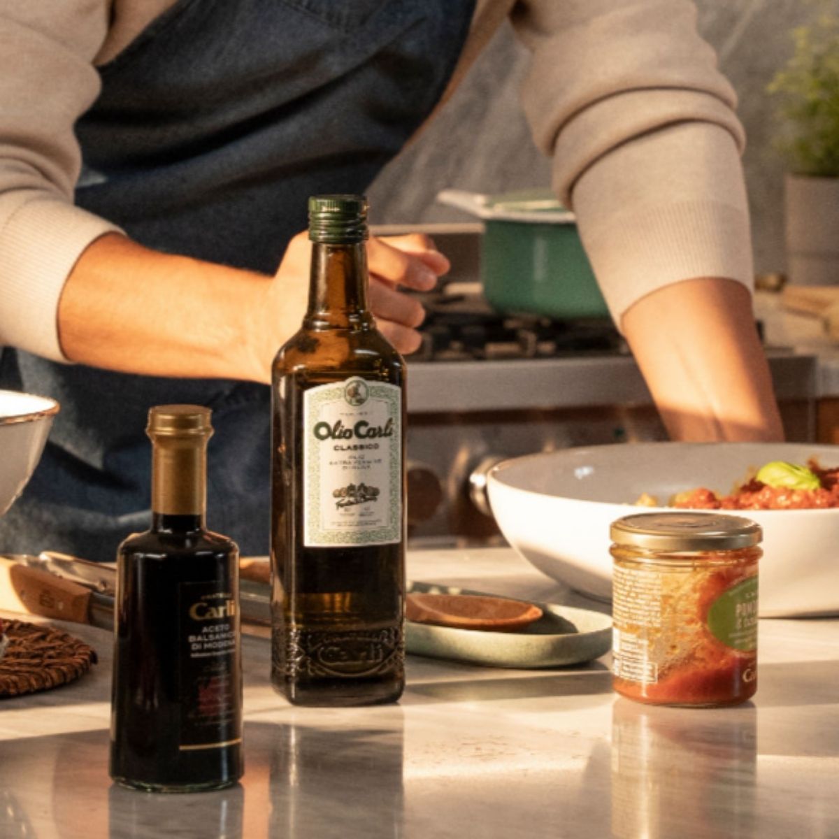 Una bottiglia di OLIO CARLI Extra Vergine di Oliva classico accanto ad una bottilia di Aceto Balsamico di Modena Fratelli Carli