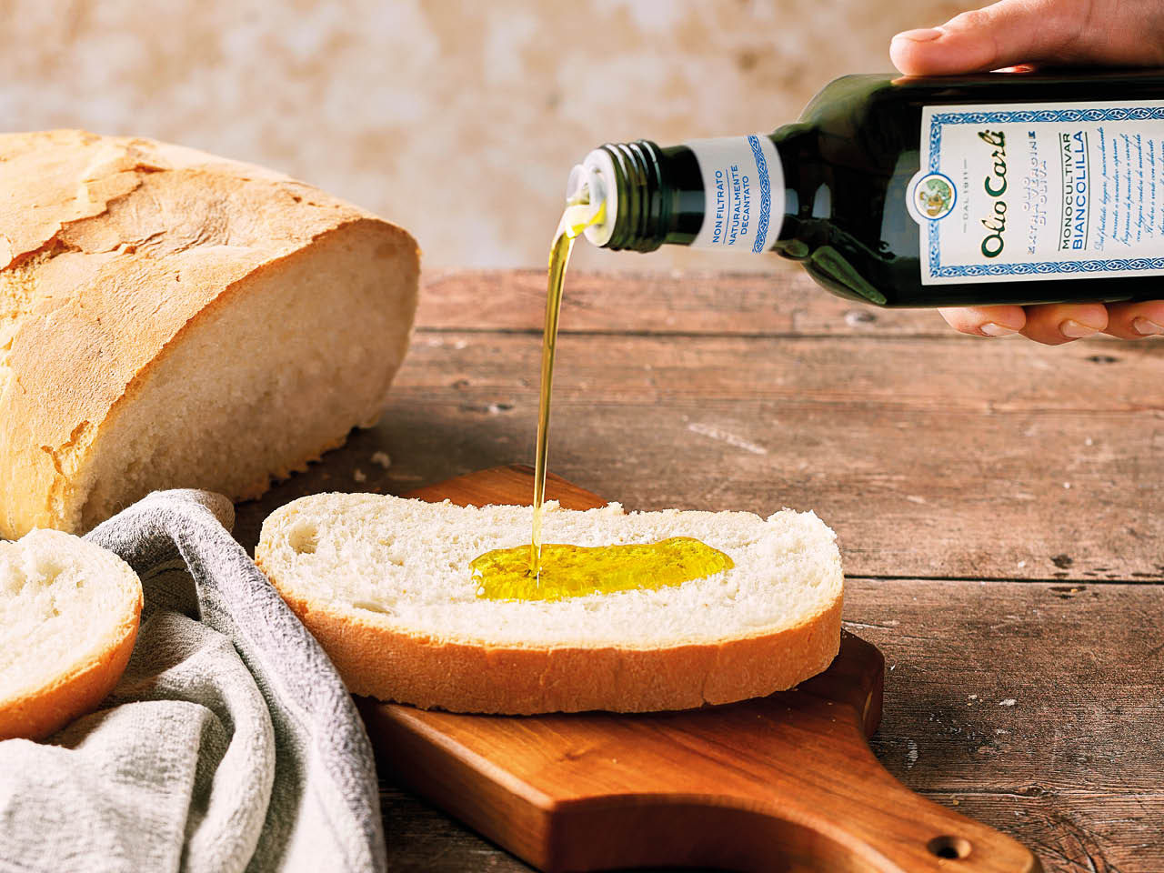 versata di olio extravergine di oliva Biancolilla su un pezzo di pane