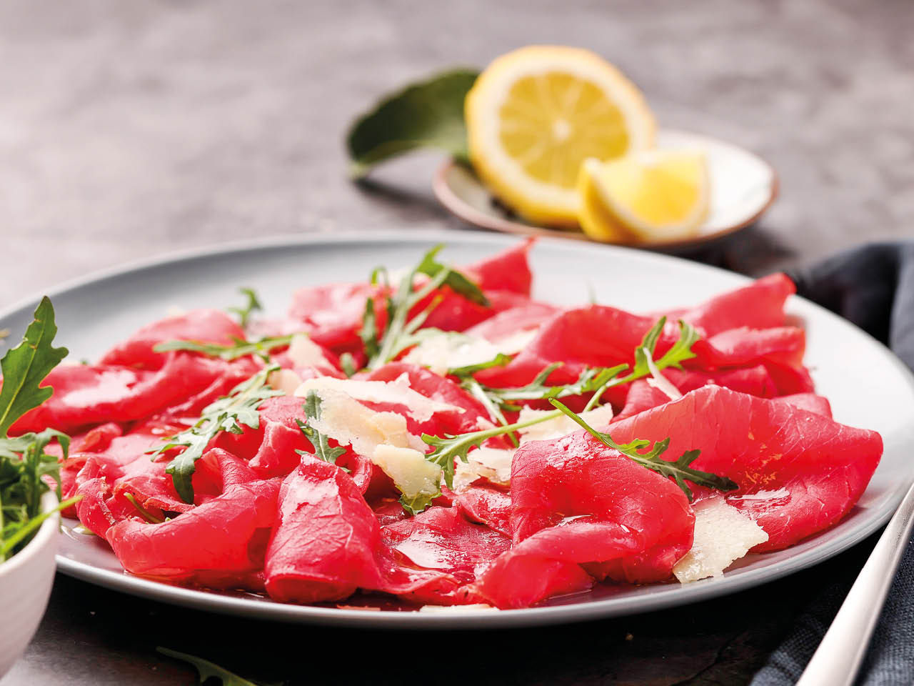 Piatto di bresaola con rucola e scaglie di grana